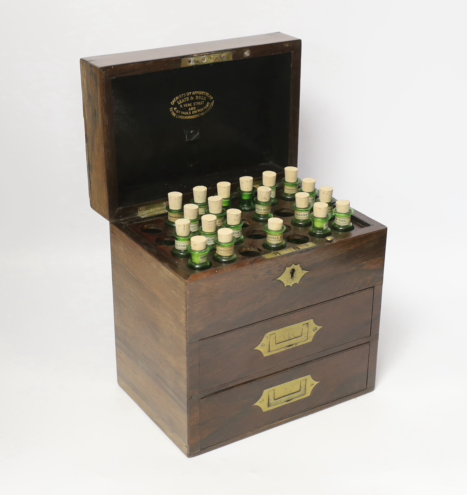 A Victorian rosewood homeopathic apothecary box, by Leath and Ross, two segmented drawers below a top opening section, containing a number of labelled chemists bottles, 21cm high, 20cm wide, 13.5cm deep